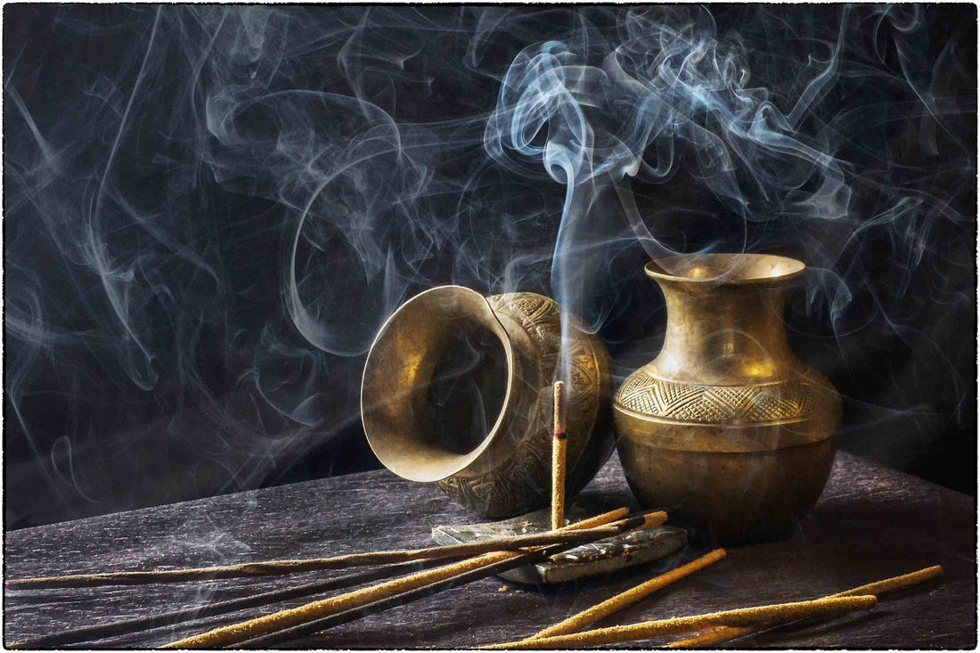 A spiral of incense smoke rising through quiet light
