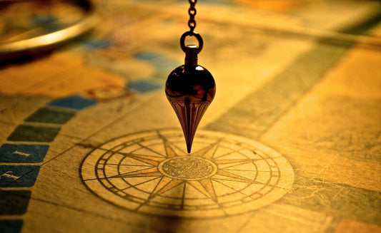 A divination pendulum swinging over a chart